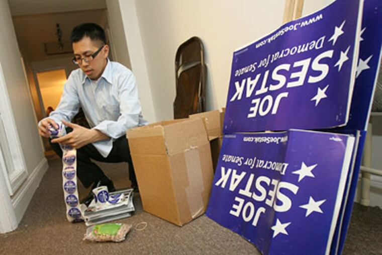 Campaign volunteer Clarence Tong works past midnight Wednesday assembling packets of stickers and fliers that will be distributed at commuter train stations in the morning. (Charles Fox / Staff Photographer)