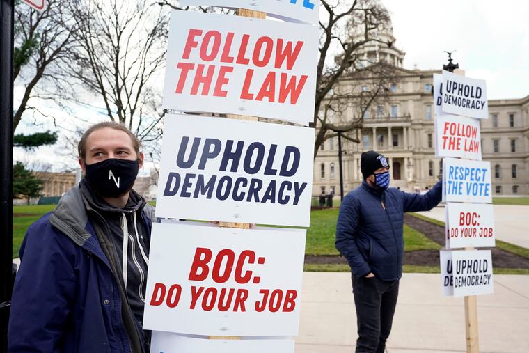 Joscha Weese, left, stood outside the Capitol building during a rally in Lansing, Mich., on Nov. 14.