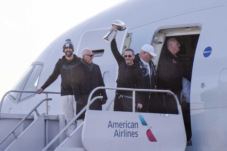 General manager Howie Roseman lifts the Lombardi Trophy as the Eagles arrive in Philadelphia from their Super Bowl LIX win in New Orleans.