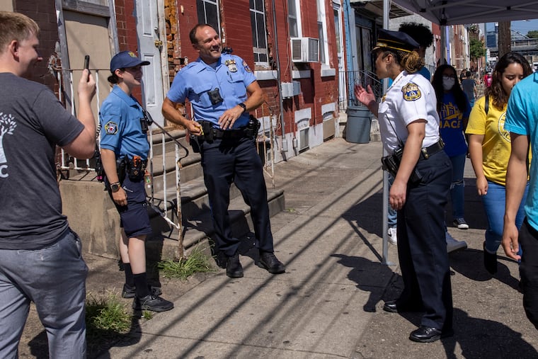 Police officer John Rajkowski with the 24th District jumped into a game of street soccer with kids with the Kensington Soccer Club. At right is Police Commissioner Danielle Outlaw applauding his skills. Philadelphia Police 24th District held a "Block Party" along E. Somerset in their district.