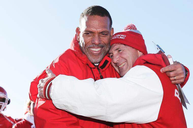 Paulsboro football coach Glenn Howard (left) is hugged by fellow coach Paul Morina after Howard won his 300th career game on Saturday.