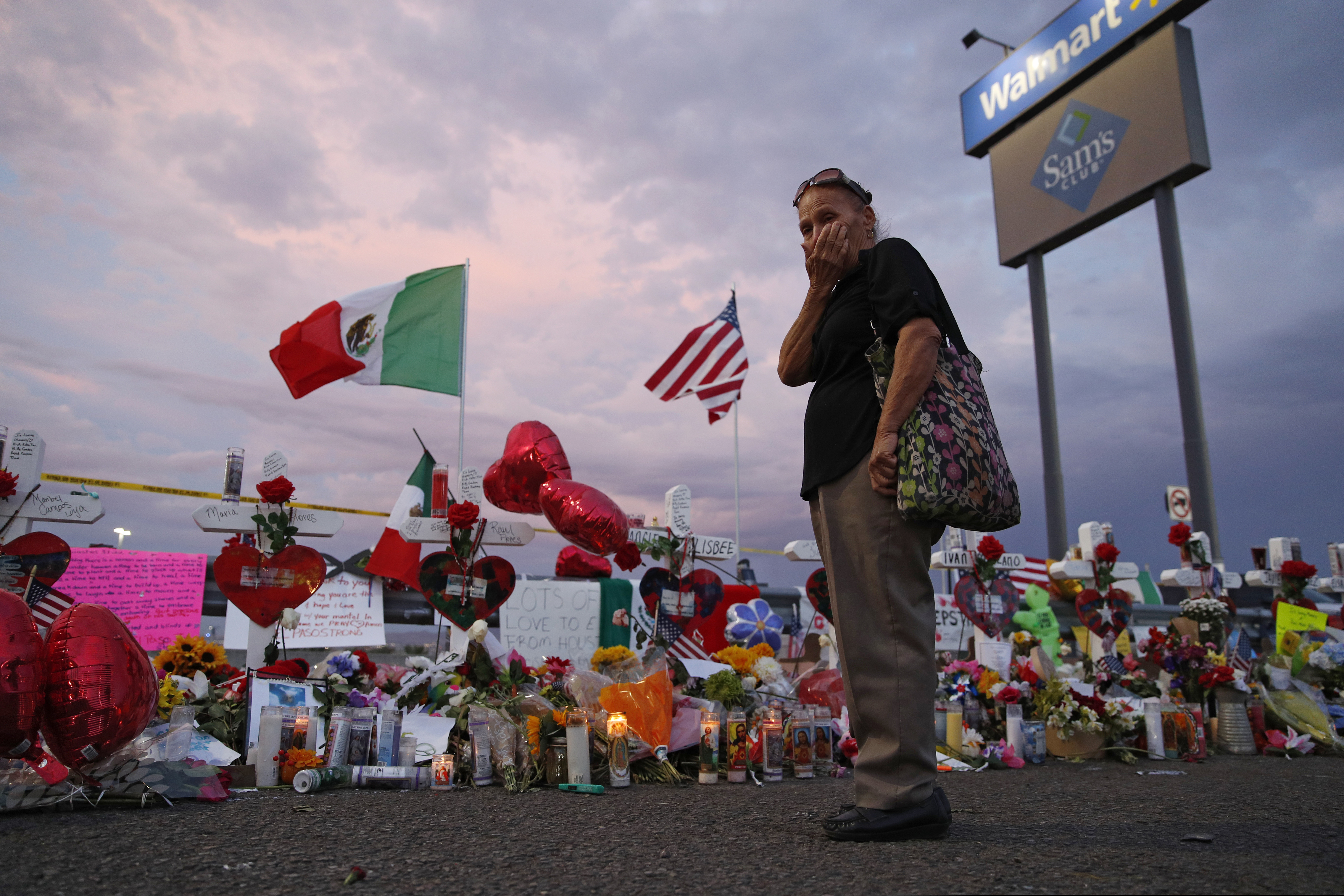 Catalina Saenz wipes tears from her face as she visits a makeshift memorial near the scene of a mass shooting at a Walmart in El Paso, Texas, last month.