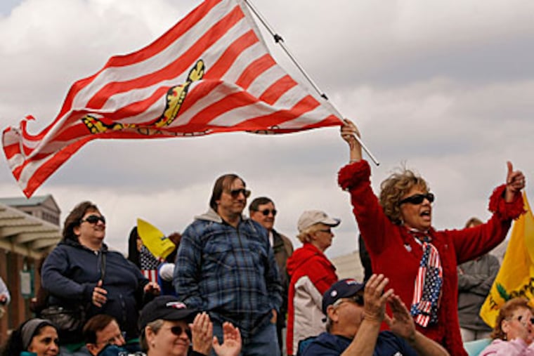 Harriet Ricchini of Medford waves a "Don't Tread on Me" flag during a tea party rally on Independence Mall in 2010.