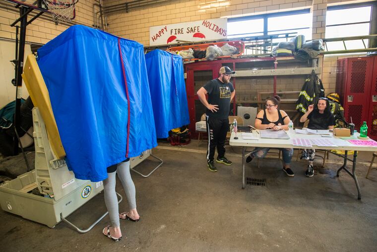 At the Engine 49 polling station John Chambers, inspector, left, Morgan Calvert, machine inspector, middle, and Dawn Chambers, clerk, right, work the tables in the back of the engine house in South Philadelphia as a voter cast their ballot on May 15, 2018.