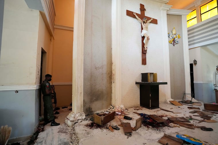 A police officer stands guard inside the St. Francis Catholic Church, a day after an attack that targeted worshipers in Owo, Nigeria. The gunmen who killed 50 people at a Catholic church in southwestern Nigeria opened fire on worshippers both inside and outside the building in a coordinated attack before escaping the scene, authorities and witnesses said Monday.