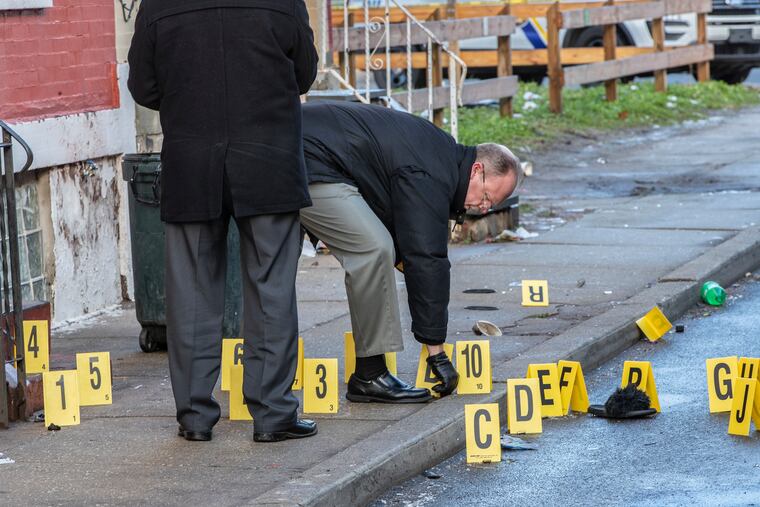 Philadelphia police investigators gather up the bullet shell casings on the 2400 block of North Patton Street Sunday morning, Jan. 19, 2020, after two men were found with gunshot wounds in the early hours of Sunday morning. Both men were taken to Temple University Hospital.