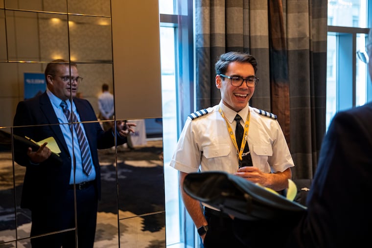 Ryan Hollinsworth, of Raleigh, N.C., a first officer at Republic Airways, talks with a guest during the Pilot Job Fair hosted by Future & Active Pilot Advisors at the Element Hotel in Philadelphia on Saturday.