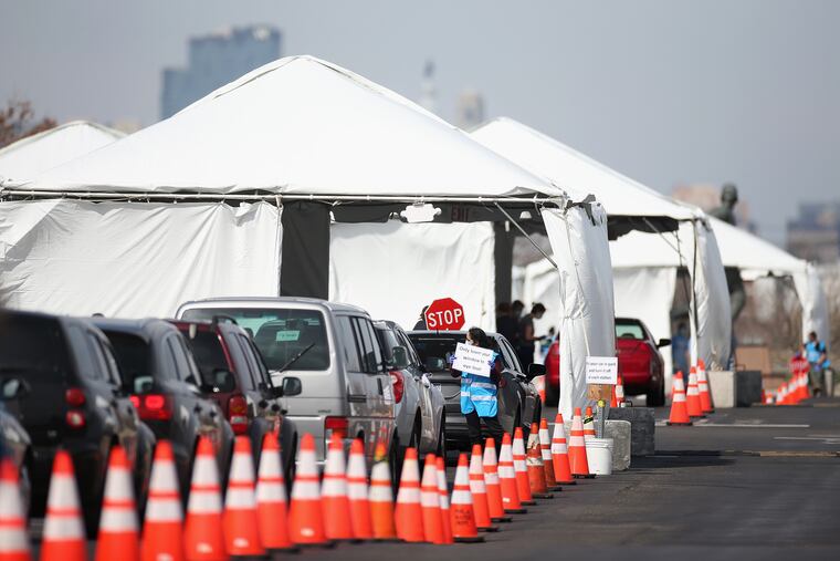 Cars wait in line at the city's coronavirus testing site next to Citizens Bank Park in South Philadelphia on Friday, March 20, 2020. The site, which opened Friday afternoon, is the first city-run drive-through location where people can be swabbed to determine if they have the coronavirus. At the time of opening, it was only for people with symptoms who are over 50 and healthcare workers with symptoms.