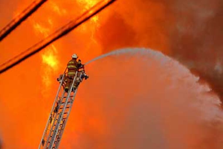 Firefighters battle an enormous fire that began at the Riverwalk at Millennium apartment complex in Conshohocken. (Sharon Gekoski-Kimmel / Inquirer)