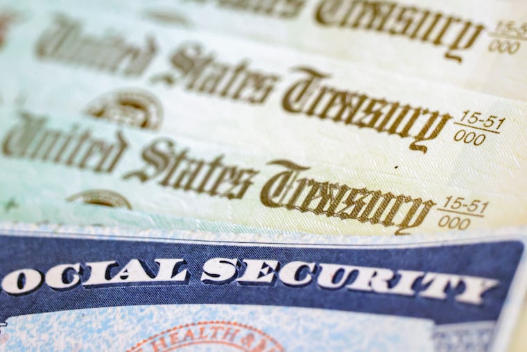In this photo illustration, a Social Security card sits alongside checks from the U.S. Treasury.