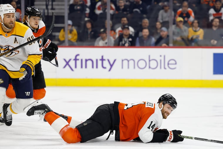 Flyers center Sean Couturier hits the ice as Nashville Predators center Ryan O'Reilly skates away during the first period on Thursday. Couturier later left the game with an undisclosed injury.