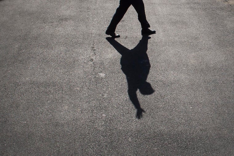 President Donald Trump's shadow is seen on the driveway as he waves and walks to board Marine One in May 2017.