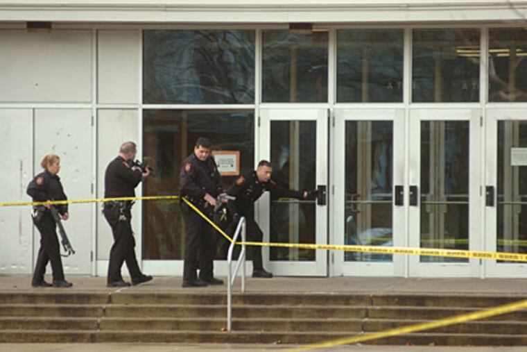 Law enforcement officers approach the exterior of Antietam Middle-Senior High School with weapons drawn. Three students were stabbed Wednesday morning at the school, in Lower Alsace Township near Reading.