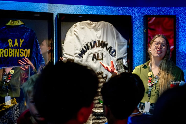 Guide Erin Dempsey tells visitors about Muhammed Ali’s robe from his fight with George Foreman. It is among the sports treasures on display as part of a new exhibit, "The Forgotten Freedom," at the National Liberty Museum in Old City. The exhibit explores the right to assembly through the power of sport. (March 11, 2026).