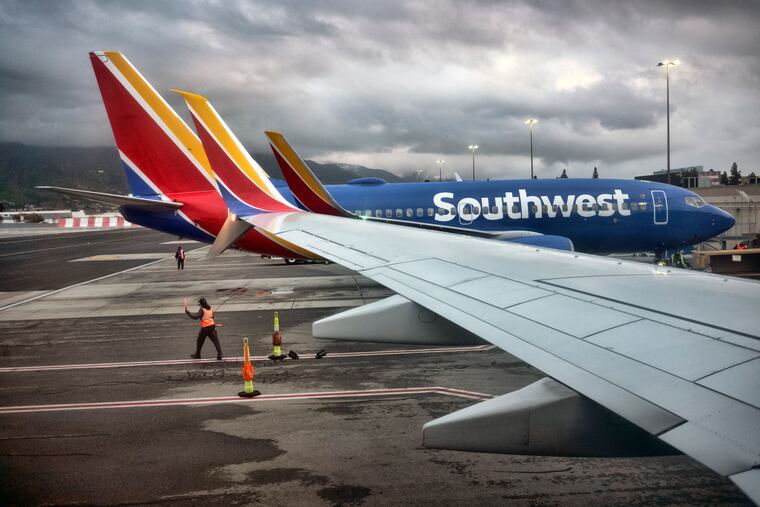 A Southwest Airlines ground crew directs a plane out of the terminal at Hollywood Burbank Airport in Burbank, Calif., in February.