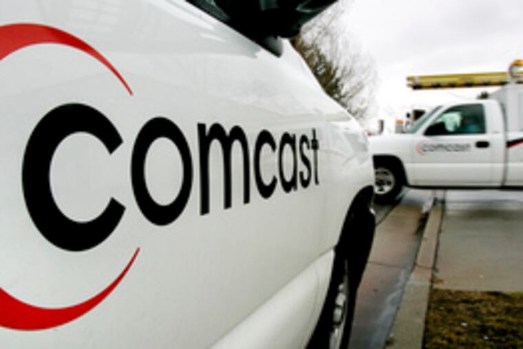Two Comcast trucks in Salt Lake City last year. Yesterday, the Philadelphia-based company said it had agreed to spend $570 million to buy stakes in sports networks in California and New England.