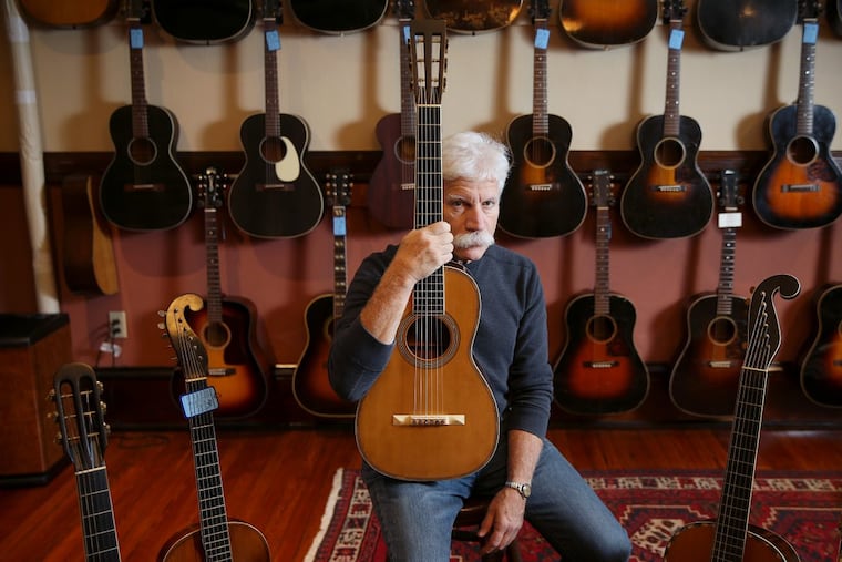 Fred Oster, who owns Vintage Instruments with his wife, Catherine Jacobs, sits for a portrait at the store with an early Martin guitar. The store will host an exhibition of 35 early Martin guitars Dec. 1-2.