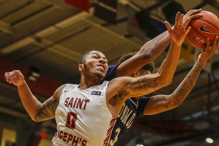 Hawks' Fresh Kimble reaches for the basketball against Monmouth guard Deion Hammond during the first half.