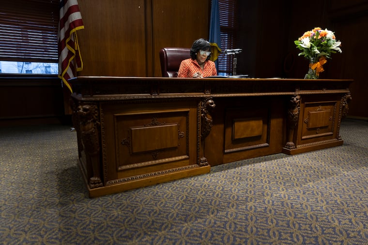 Mayor Cherelle Parker signs executive orders in her new office in City Hall on Tuesday. She has yet to decorate or add much furniture to the office.