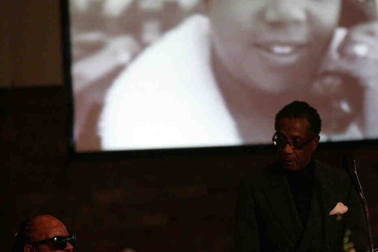 Stevie Wonder sings at the funeral service for Esther Gordy Edwards as her only son, Robert Bullock, looks on.
