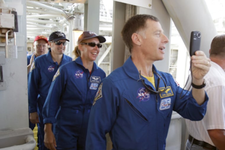 2011: Chris Ferguson, commander of the shuttle Atlantis, makes a video with his cellphone as he and (from left) pilot Doug Hurley and mission specialists Rex Walheim and Sandy Magnus walk down to emergency safety training. (John Raoux / Associated Press)
