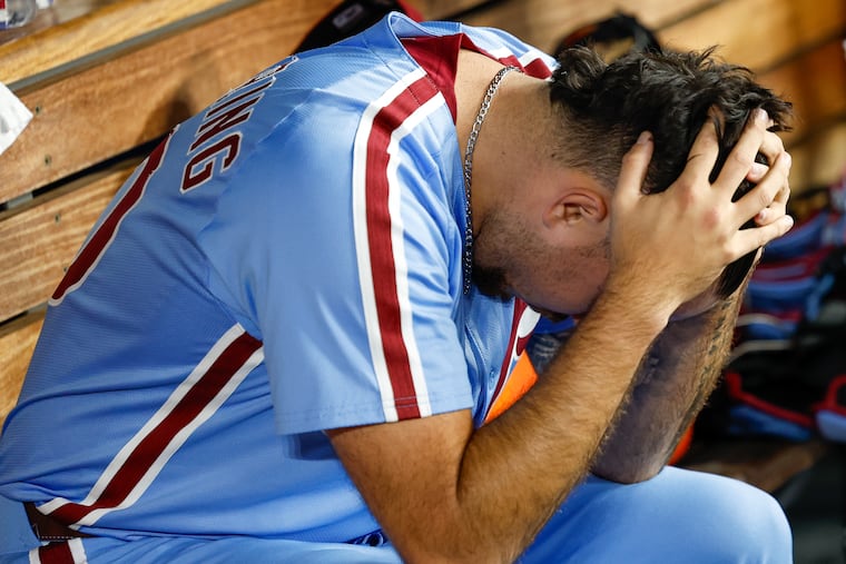 Phillies pitcher Orion Kerkering reacts in the dugout after his throwing error ended the game and the series against the Dodgers.
