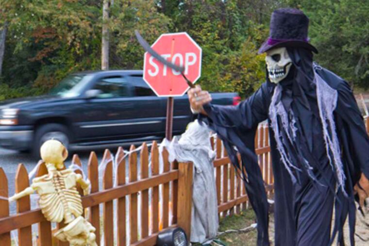 Dave Newman of Evesham entertains motorists passing his elaborately decorated property. DAVID M WARREN / Staff Photographer