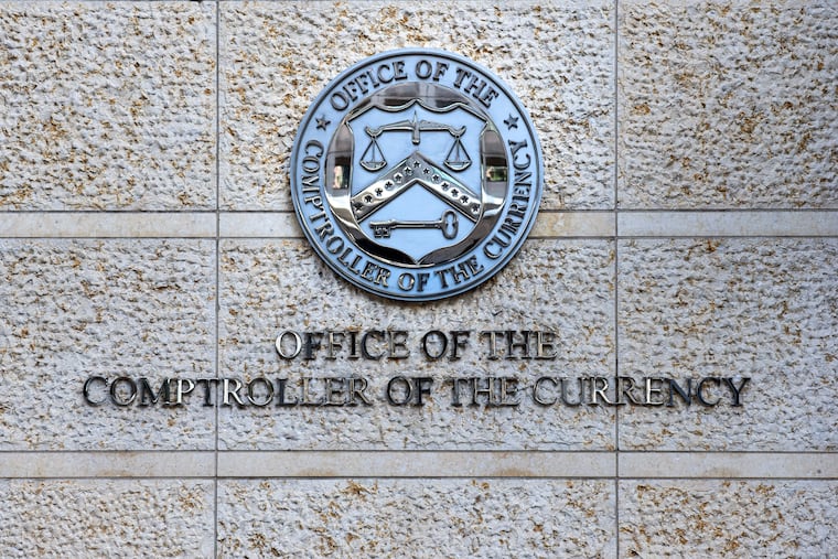 FILE - The official seal of the Office of the Comptroller of the Currency is seen on an office building in Washington, Feb. 13, 2026. (AP Photo/Cliff Owen, File)