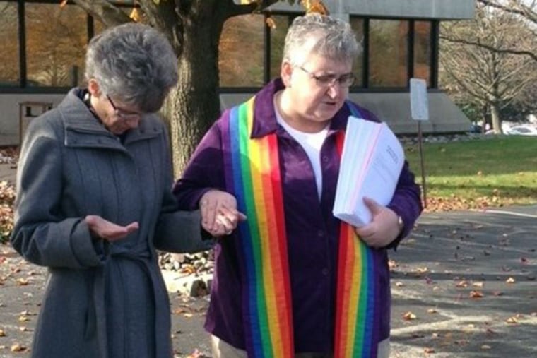 Methodist Bishop Peggy Johnson, left, prays with Rev. Karyn Wiseman Thursday after Wiseman gave her a 25,000-signature petition seeking to end trials in the Methodist church. (Tricia Nadolny/Staff)