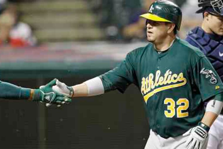 The A's Jack Cust (32) is greeted after his two-run home run Tuesday.