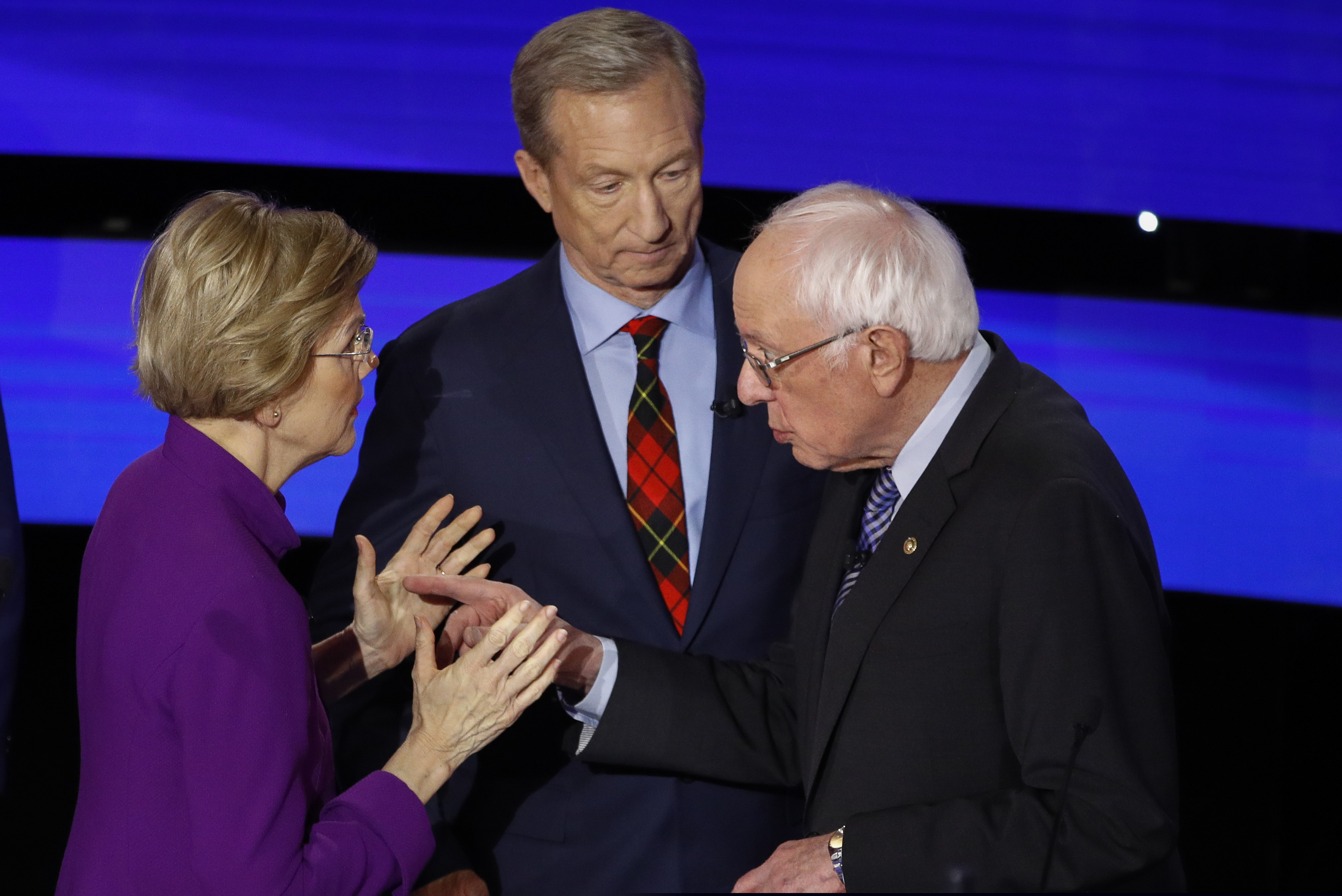 Democratic presidential candidate Sen. Elizabeth Warren (D., Mass.) and Sen. Bernie Sanders (I., Vt.) talk Tuesday after a Democratic presidential primary debate hosted by CNN and the Des Moines Register in Des Moines, Iowa., as businessman Tom Steyer looks on.