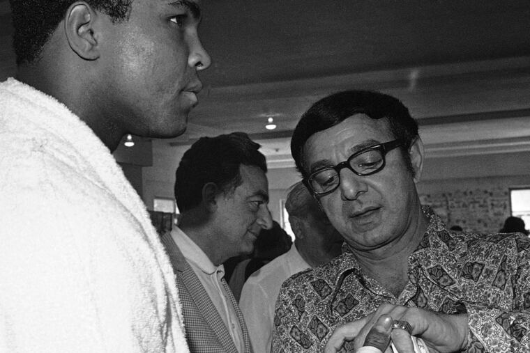 Muhammad Ali gets his fists taped by trainer Angelo Dundee in March 1971, as Ali prepared for his first fight with Joe Frazier.