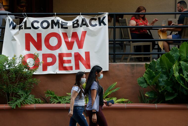 Visitors to the River Walk pass a restaurant that has reopened in San Antonio in May. Coronavirus cases are rising in nearly half the U.S. states, as states are rolling back lockdowns. (AP Photo/Eric Gay, File)