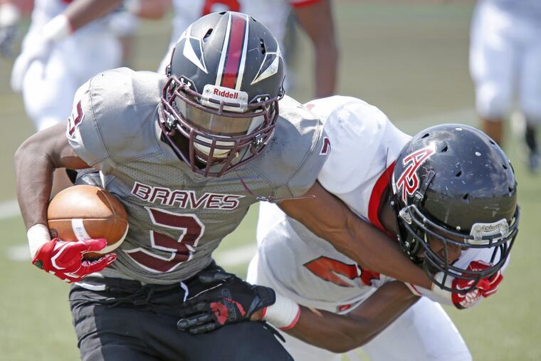 Bartram’s Fred Lackay (3) holds off Archbishop Ryan’s Mekhi Lang and scores a two-point conversion in the first quarter of the Braves’ 22-12 nonleague win Saturday.