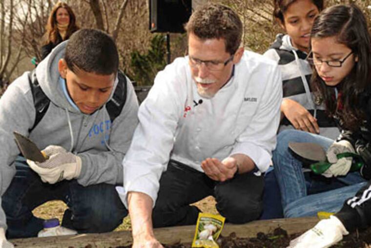 In March, chef Rick Bayless, first "Top Chef Masters" winner, planted organic seeds with students at a New York Restoration Project community garden in East Harlem. (Associated Press)