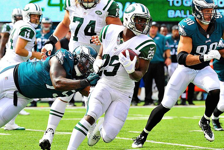 Jets running back Bilal Powell is taken down by Eagles defensive end Vinny Curry.