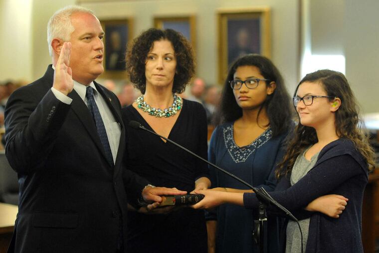 Matthew D. Weintraub is sworn in as the new Bucks County district attorney as wife Kathleen and daughters Shayna, 15, and Chloe (right), 11, hold the Bible in September. Weintraub succeeded David W. Heckler, who retired.