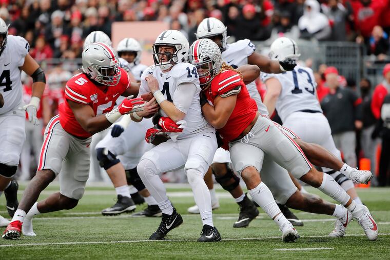 Ohio State defensive end Chase Young (2) and linebacker Baron Browning (5) sack Penn State quarterback Sean Clifford during the first quarter.