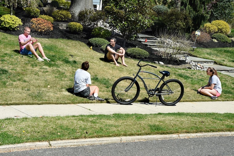 High school classmates, all home from their freshman year in college because of the coronavirus, maintain social distancing at they hang out in Haddonfield.