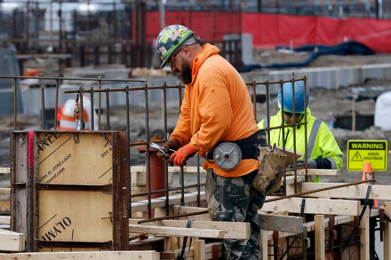 A construction worker wires rebar for a foundation in Boston in March.