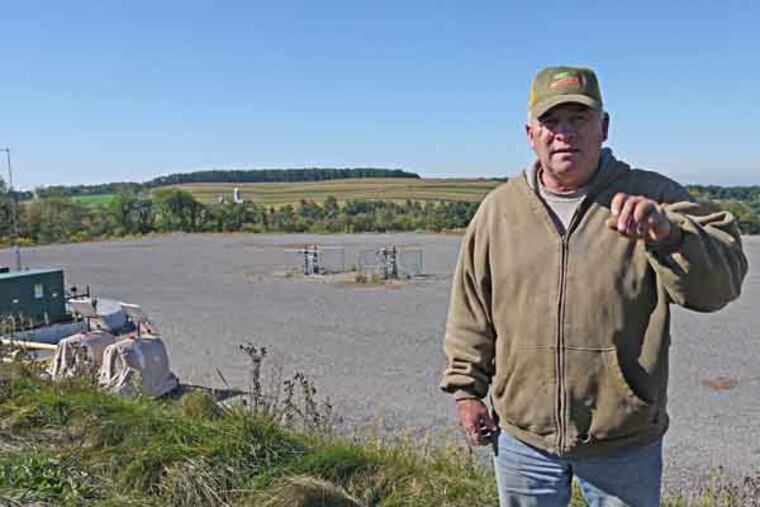 Robert Marquardt, a beef cattle farmer outside of Hughesville, Pa., said there has been no lasting damage from the spill of Marcellus Shale wastewater that happened at the well site on his farm in 2010. He stands on the edge of the gravel well site. The spill happened on the edge of the well pad in the distance, and more than 50,000 gallons of wastewater went over the side. Photo by Andy Maykuth