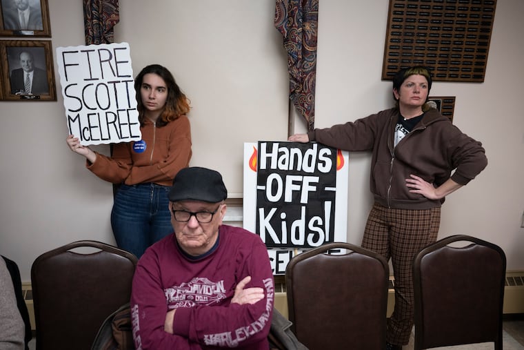 Alexa McDonald (left) and Bonnie Koehler display signs during a council meeting as members of the community speak out against the actions of Police Chief Scott McElree on March 4 in Quakertown.
