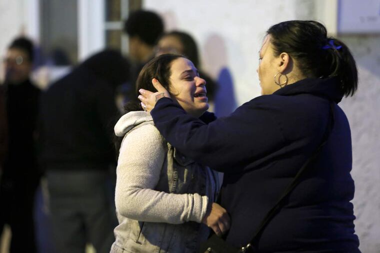 Residents grieve as on Jasper Street near Glenwood Avenue, Monday Nov. 23, 2015, in Harrowgate, where two men were found dead.