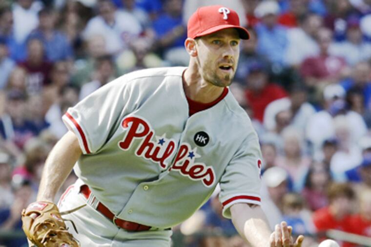 Cliff Lee tosses a ground ball by Chicago Cubs' Ryan Theriot to first baseman Ryan Howard during the seventh inning of the Phillies' 6-1 win today. (AP Photo/Charles Rex Arbogast)