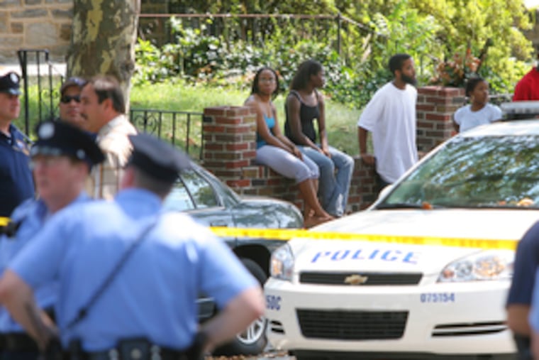 Police and neighbors linger in 6800 block of North 19th Street.
