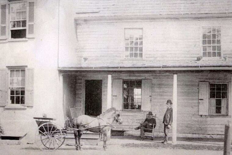 Andrew McNeal sits in a rocking chair on the porch of what could be Jegou's Tavern in a photograph from about 1890.
