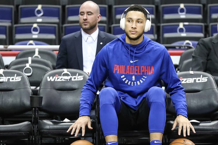 Sixers point guard Ben Simmons watches warm-ups before making his regular season NBA debut.