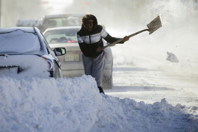 Someone digs out a car on Madison Ave. in Atlantic City a day after a bomb cyclone brought a foot of snow and high winds to the region.