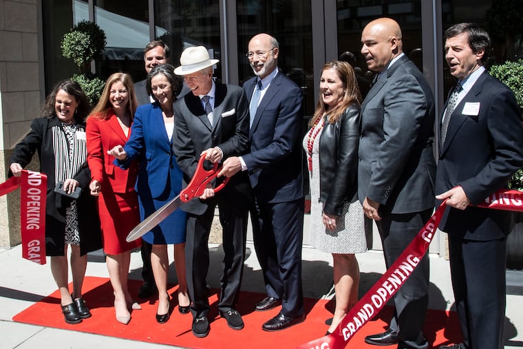 Dranoff Properties CEO Carl Dranoff (in hat) and Gov. Tom Wolf (also holding scissors) cut the ribbon during a celebration Tuesday of the completion of One Ardmore, a disputed apartment building in Lower Merion.