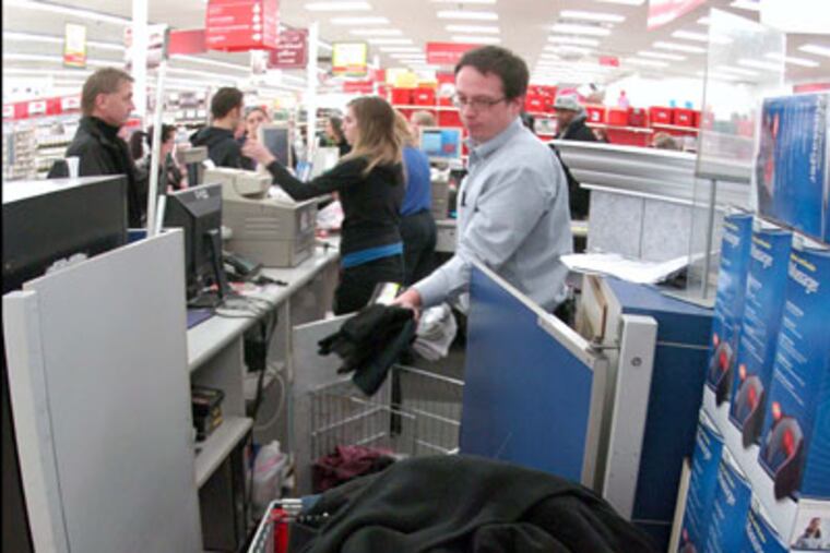 Store employee John Floryan, center, puts returns into a shopping cart at the Wilkes-Barre Twp, Pa. Kmart Monday, Dec. 26, 2011. (AP Photo/The Citizens' Voice, Mark Moran) MANDATORY CREDIT